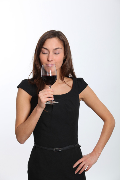 Beautiful woman in black dress tasting red wine - Zdjęcie, obraz