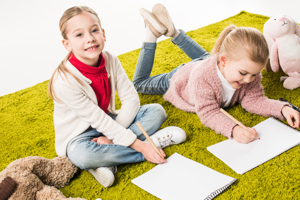 beautiful little sisters drawing together on floor isolated on white - Fotografie, Obrázek