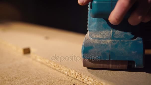 κοντινό πλάνο του χεριού ξυλουργοί που γυαλίζει και την ξύλινη επιφάνεια με τρυπάνι - Πλάνα, βίντεο