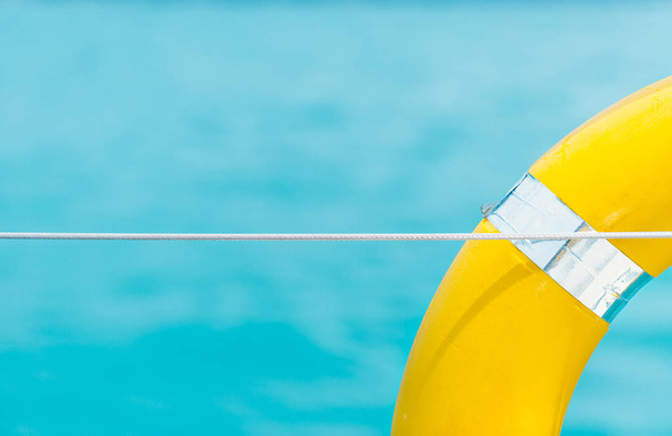 Close-up Gele levensring hangend op boot met oceaanachtergrond. - Foto, afbeelding
