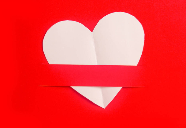 Papel branco em forma de coração em fundo vermelho, Coração cortado a partir de branco
 - Foto, Imagem