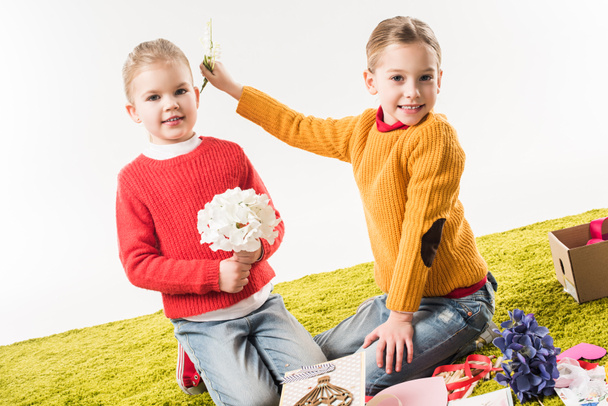 little sisters sitting on floor while making mothers day greeting card isolated on white - Valokuva, kuva