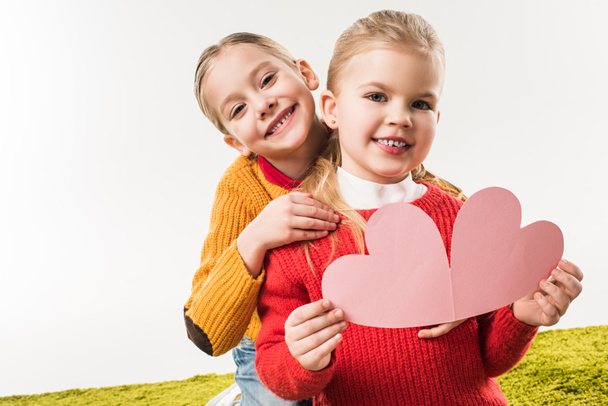 petites sœurs avec coeur en carton rose pour carte de vœux faite à la main isolée sur blanc
 - Photo, image