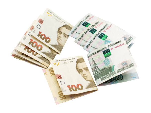 Cent hryvnia de monnaie nationale ukrainienne et mille roubles de russe isolé sur fond blanc. Finances, politique internationale
 - Photo, image