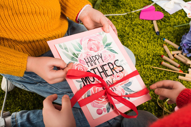 tiro recortado de los niños pequeños que preparan la tarjeta de felicitación para el día de las madres
 - Foto, imagen