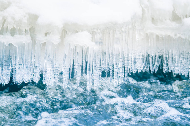 A beautiful frozen icicles at the bank of river in Latvia. Beautiful winter scenery. - Photo, Image
