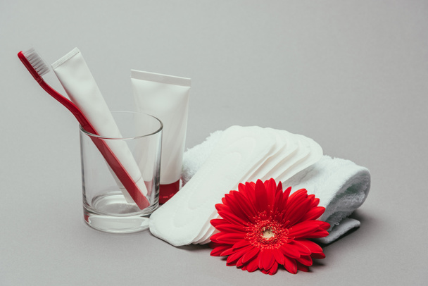 vue rapprochée des fournitures d'hygiène, fleur et serviette isolées sur gris
 - Photo, image