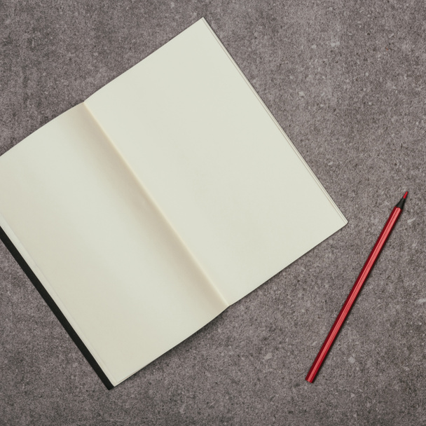 Close-up van lege notebook en marker op grijze oppervlak - Foto, afbeelding