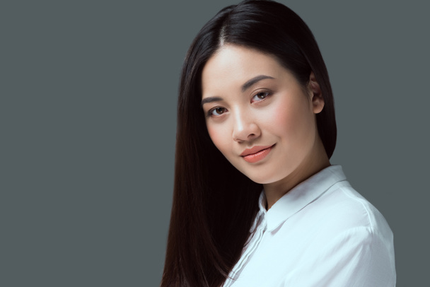 ritratto di bella giovane donna asiatica sorridente alla macchina fotografica isolata sul grigio
  - Foto, immagini