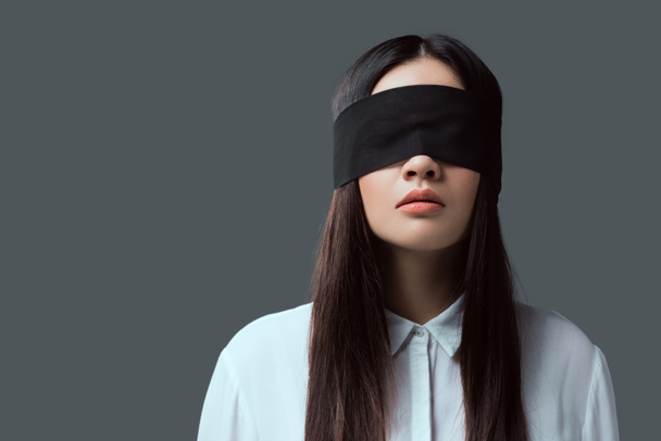 young woman wearing black blindfold isolated on grey - Фото, зображення