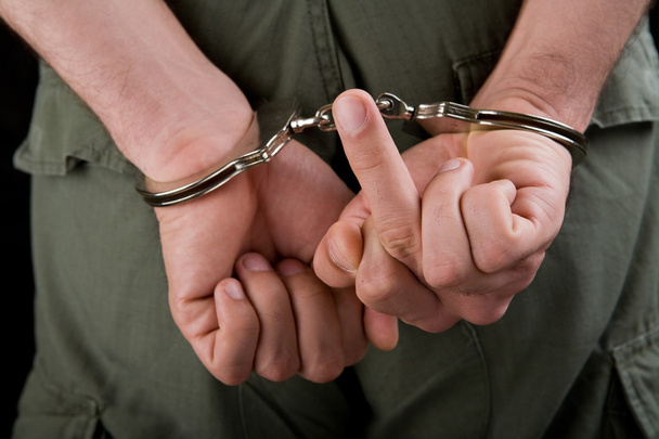 Hands in cuffs showing middle finger - Photo, Image