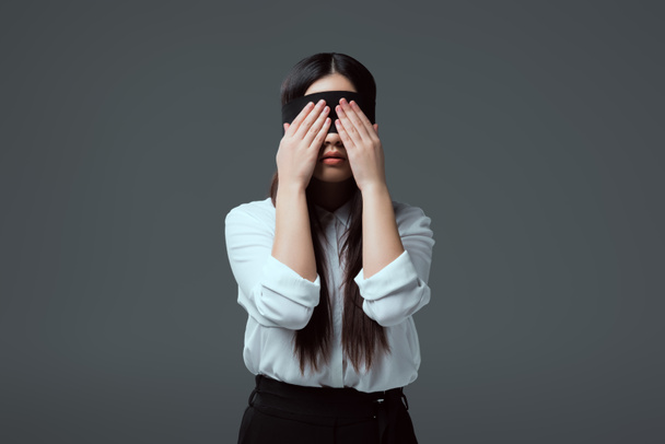 young blindfolded woman closing eyes isolated on grey   - Foto, Imagem