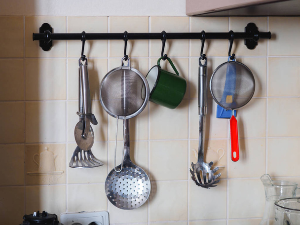 Кухонные металлические хромированные инструменты на перилах
 - Фото, изображение