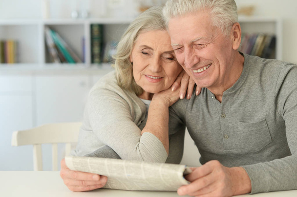 Close-up portrait of a  senior couple with newspaper  at home  - Foto, Imagen