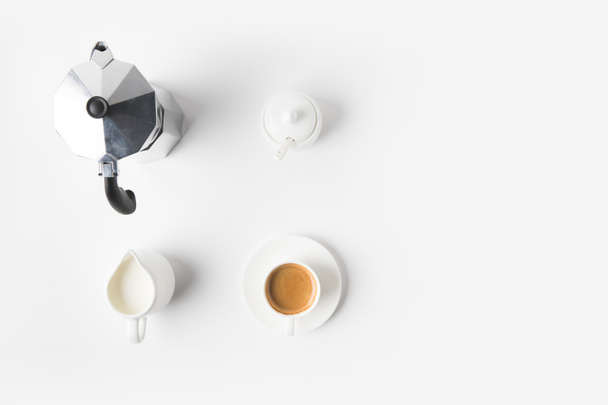 vue de dessus de tasse de café arrangée, jag de lait et cafetière sur la surface blanche
  - Photo, image