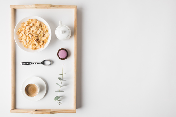 vista superior del desayuno con copos de corcho en tazón y taza de café en bandeja en la superficie blanca
 - Foto, imagen