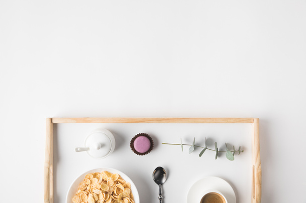 vista superior del desayuno con copos de corcho en tazón y taza de café en bandeja en la superficie blanca
 - Foto, imagen