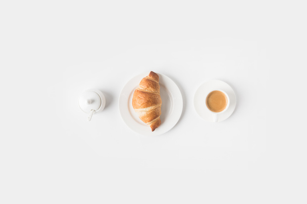 top view of cup of coffee and croissant for breakfast on white surface - Photo, Image