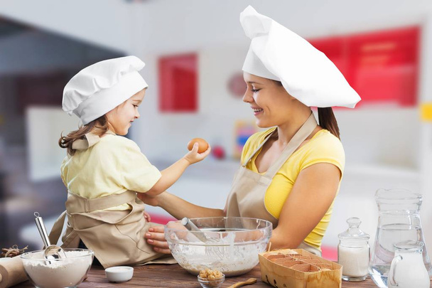 girl and her mother baking together  - 写真・画像