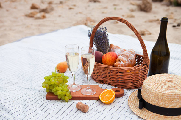 Two glasses of champagne. Picnic on the beach at sunset in the w - Φωτογραφία, εικόνα