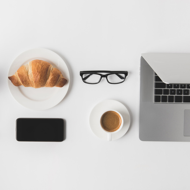 flat lay with digital devices, eyeglasses and breakfast on white tabletop - Φωτογραφία, εικόνα