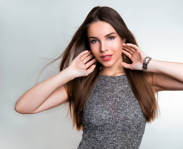 beautiful young woman with long brown hair wearing wrist watch - 写真・画像