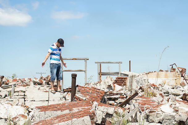 Hombre observando la destrucción de su hogar
. - Foto, imagen