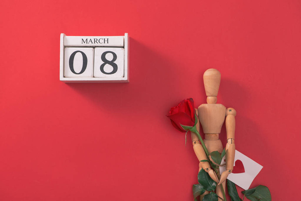 Wooden man figure with red flowers. Concept for valentine's day. - Photo, Image