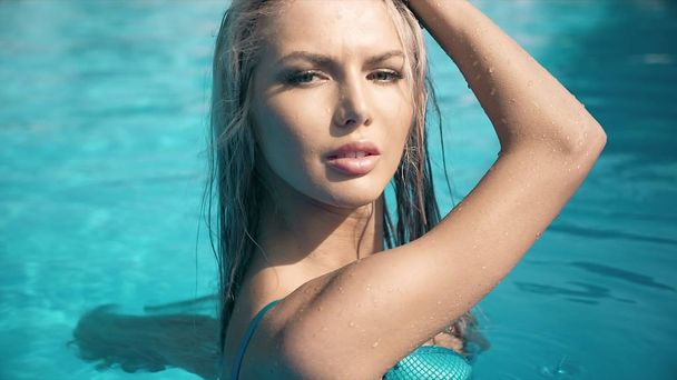 スイミング プールの空気マットレスの上に横たわる若いきれいな女性 - 写真・画像