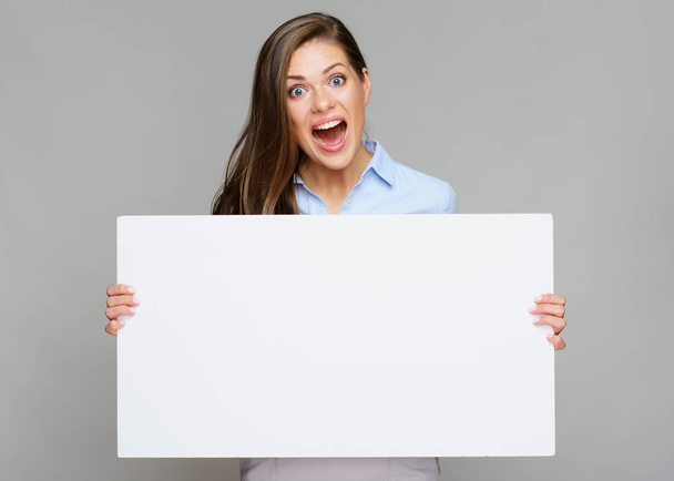 businesswoman shouting while showing white blank paper and looking at camera on grey background - Фото, изображение