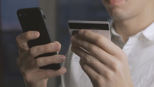 Hombre Banca en línea con Smartphone Compras en línea con tarjeta de crédito - Metraje, vídeo