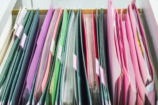 documentos de archivos colgando carpetas de archivos en un cajón en un montón de papeles completos en la oficina de trabajo, concepto de negocio
. - Foto, Imagen