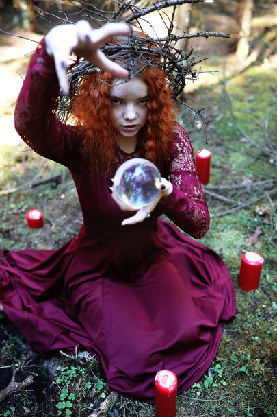 The red-haired witch holds a ritual with a crystal ball - Fotoğraf, Görsel