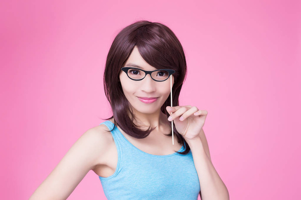 woman holding paper party stick with glasses on the pink background - Φωτογραφία, εικόνα