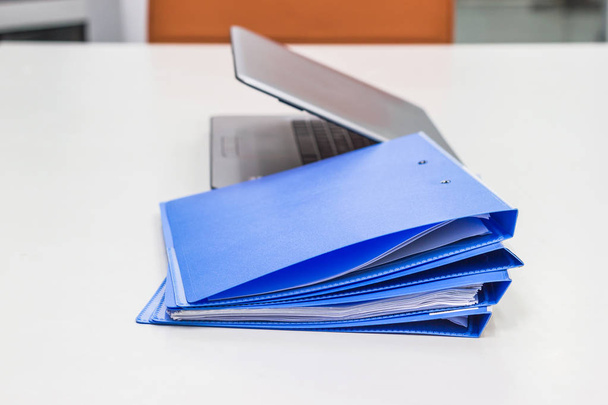 Blue file folder with documents and Notebook background on the white table bisuness concept. - Photo, Image