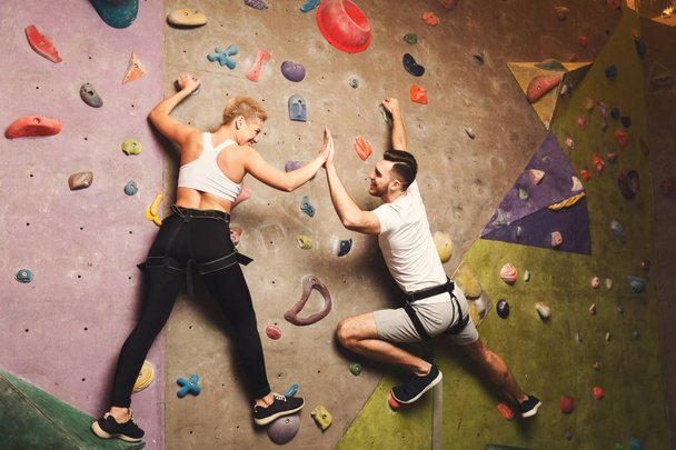 Two professionals climbing artificial rock wall at gym - Valokuva, kuva