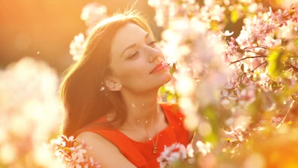 Animation video of Happy smiling young woman with spring flowers at garden - Footage, Video