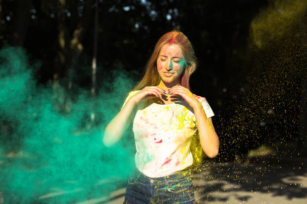 Cool молода жінка грає з жовтий і зелений сухий фарба в холі - Фото, зображення