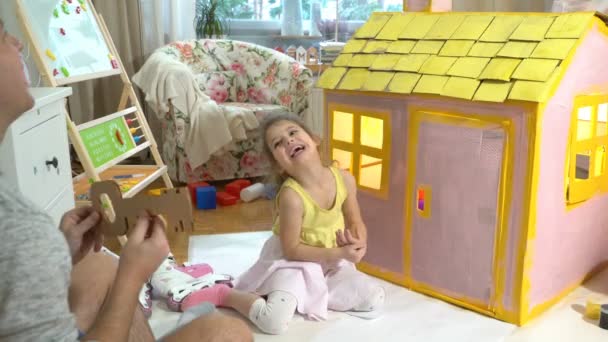 Father gives happy little girl a key to her new cardboard house. - Кадри, відео