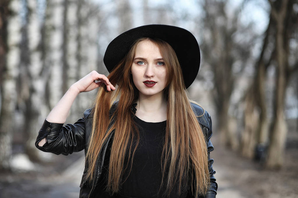 Young beautiful girl in a hat and with a dark make-up outside. G - Zdjęcie, obraz