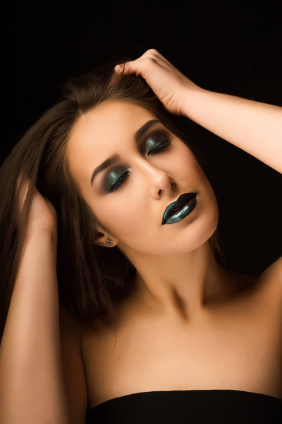 Гламурная брюнетка леди с искусством металлический зеленый макияж позируя с
 - Фото, изображение