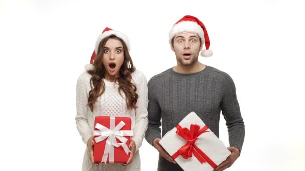 Lassított fiatal pár meglepően sokk pulóver és a karácsonyi kalap ünnepelni karácsonykor. - Felvétel, videó
