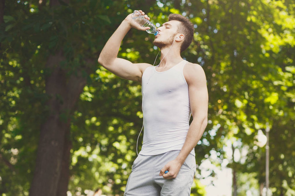 Fitness homem água potável no parque otdoors
 - Foto, Imagem