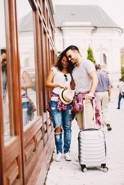 joven feliz amor pareja viajando en la ciudad y mirando escaparate con helado
 - Foto, Imagen