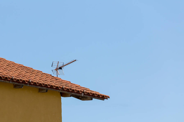 Телевізійна антена на даху старого будинку з керамічної плитки
 - Фото, зображення