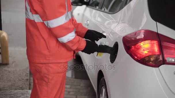 ガス駅員サービス ステーションで車を補充します。クリップ。男性作業員が車を塗りつぶします - 映像、動画