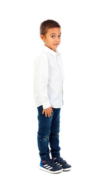 schattige gelukkig weinig Afrikaanse jongen in wit shirt en spijkerbroek geïsoleerd op witte achtergrond - Foto, afbeelding
