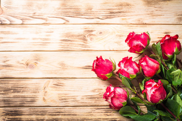 Красный цветок розы на деревянном столе
. - Фото, изображение