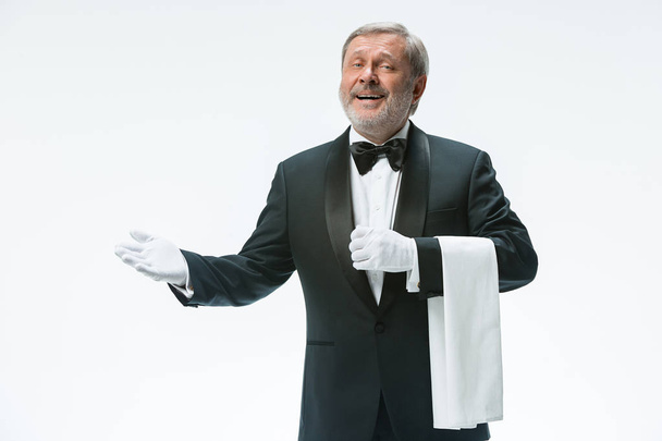 Senior waiter holding white towel - Foto, afbeelding
