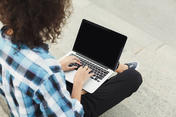 Happy young woman using laptop outdoors - Photo, image